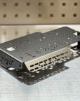Metal battery bracket with 'MSD' branding on a metallic surface