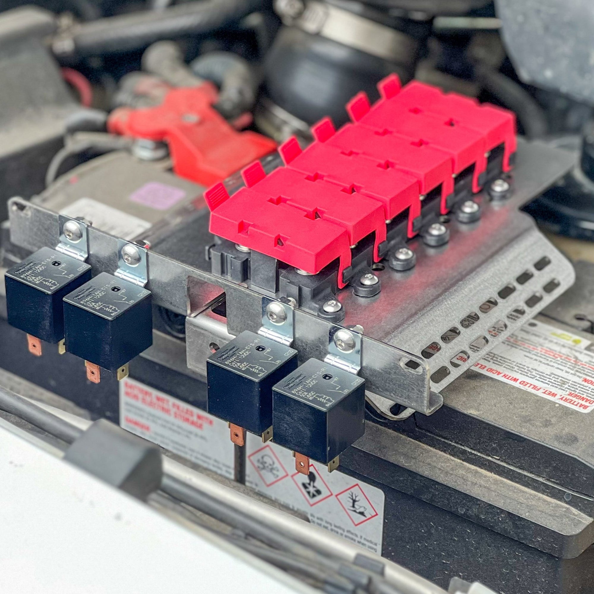 GU Patrol Battery Fuse Bracket with red fuse holders and relays installed, showcasing an organized 12-volt electrical system.