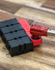 Red and black electrical connectors on a wooden surface