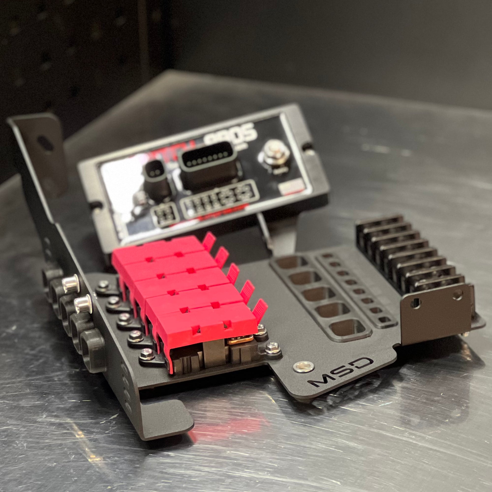 An MSD brand brushed aluminum electronic cooling heatsink and bracket assembly, featuring a bright pink heat spreader and a silver metal base plate on a brushed metal surface.