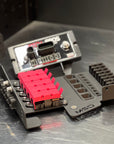 An MSD brand brushed aluminum electronic cooling heatsink and bracket assembly, featuring a bright pink heat spreader and a silver metal base plate on a brushed metal surface.