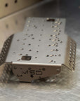 Metallic battery bracket with 'MSD' branding on a metallic surface