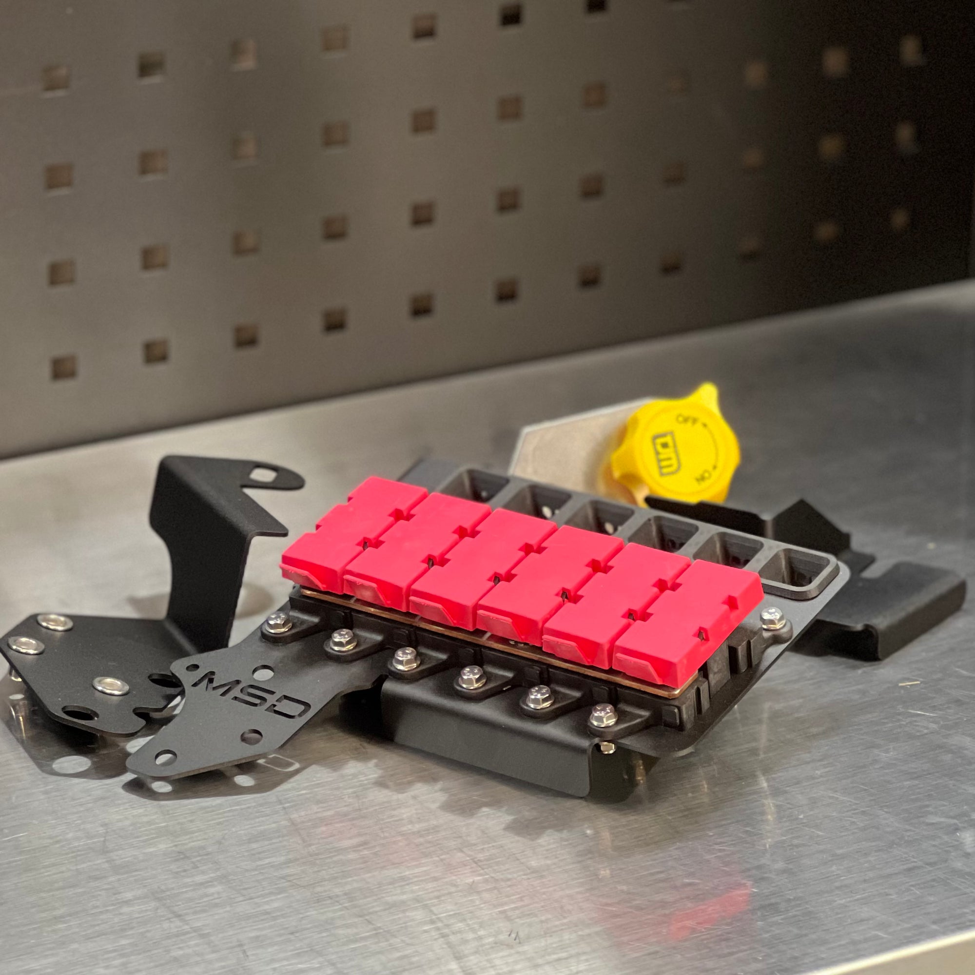 Ford F150 2021-Current MIDI Fuse Kit with red fuses and mounting hardware on a metal surface.