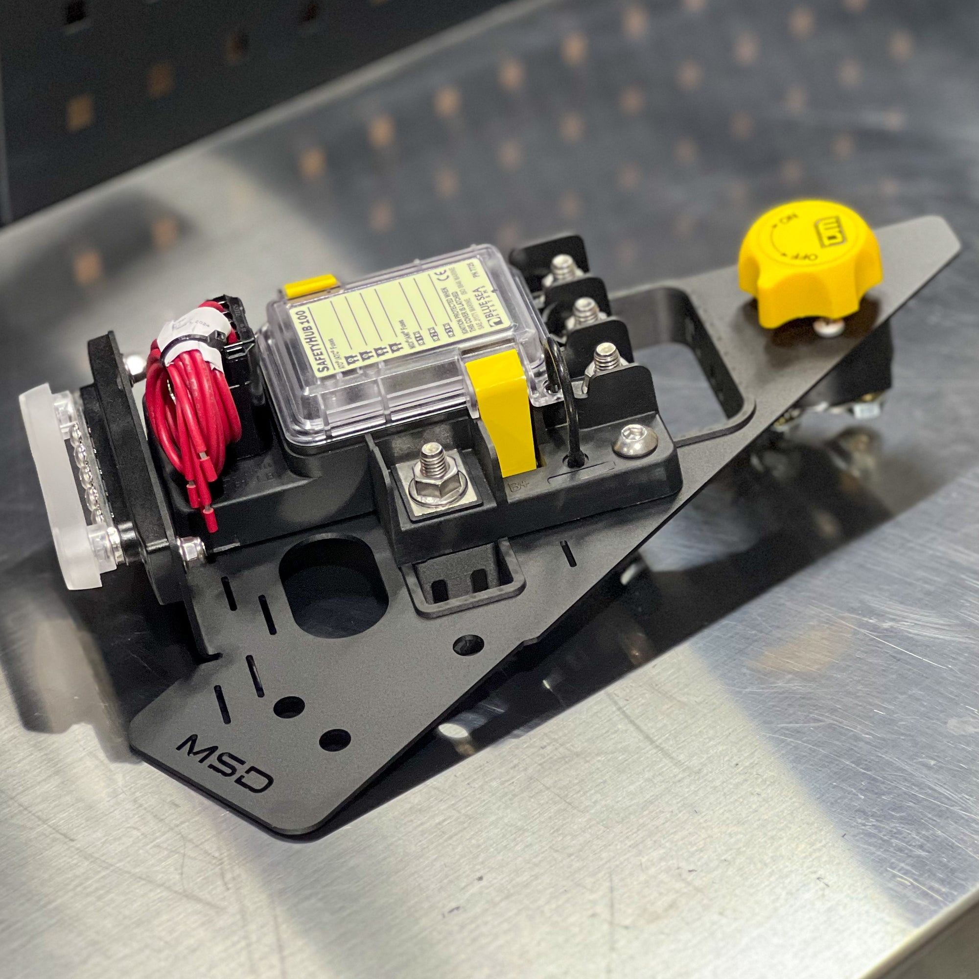 Mechanical component with wiring and a yellow cap on a metallic surface