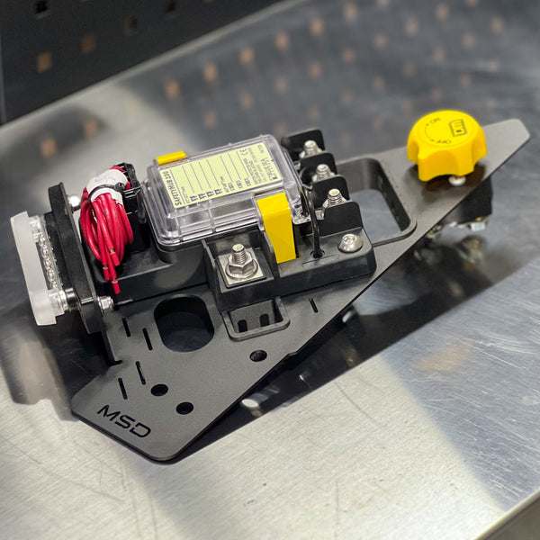 Mechanical component with wiring and a yellow cap on a metallic surface