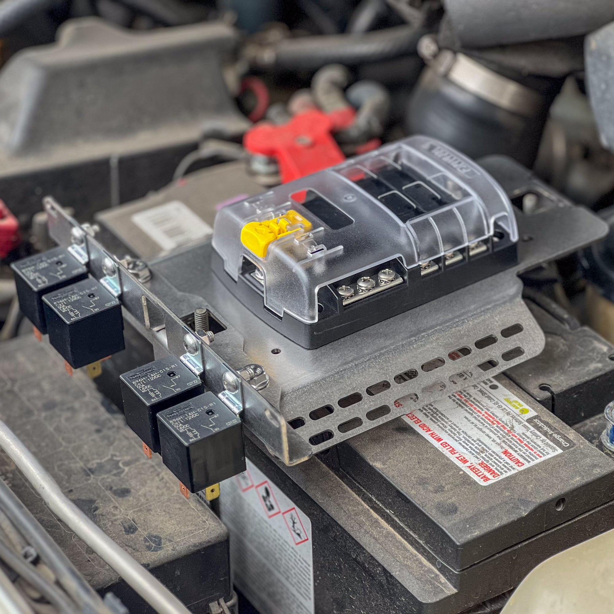 GU Patrol Battery Fuse Bracket mounted on a battery with circuit breakers for organized wiring.