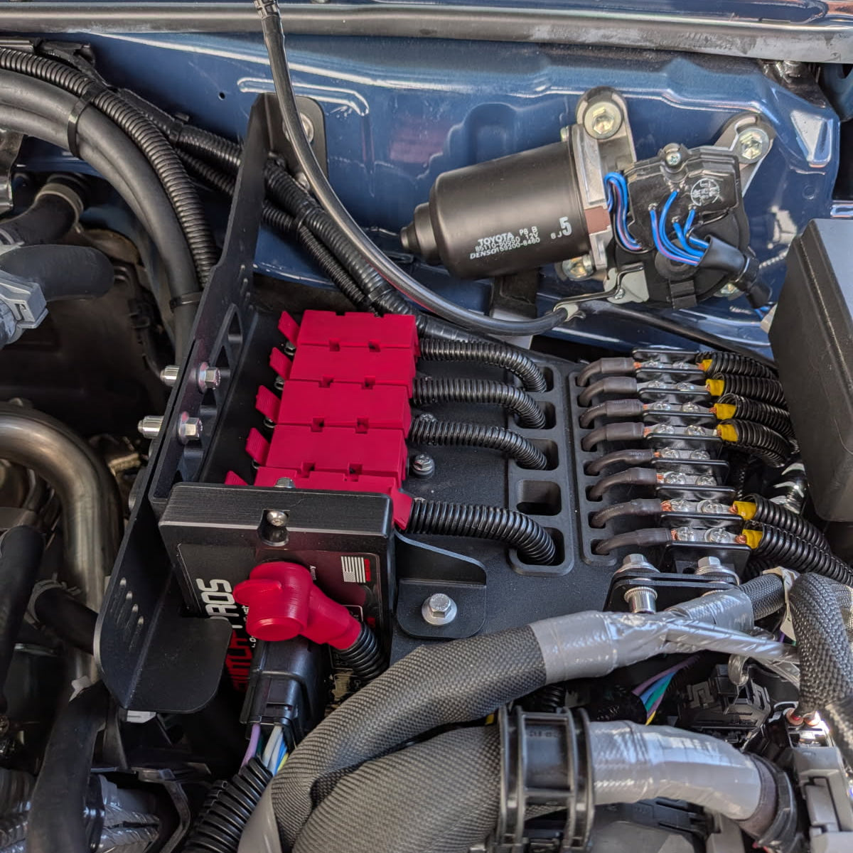 Close-up of a car engine with various components and wiring.