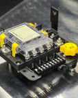 Electronic module with yellow and black components on a metallic surface
