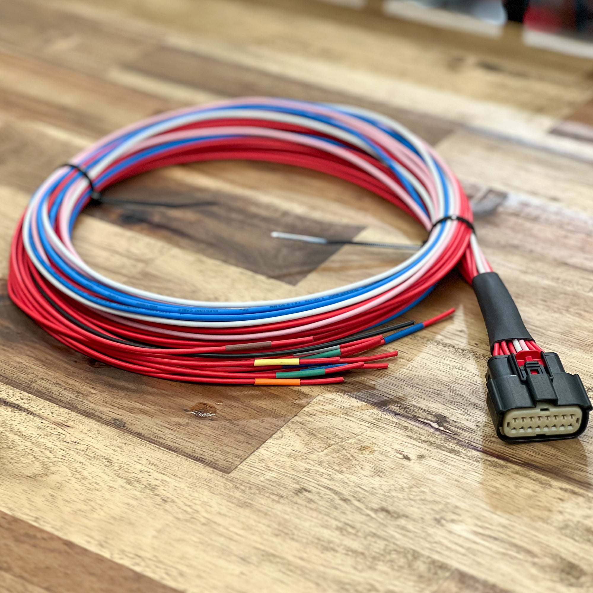 Coiled wiring harness with connectors on a wooden surface