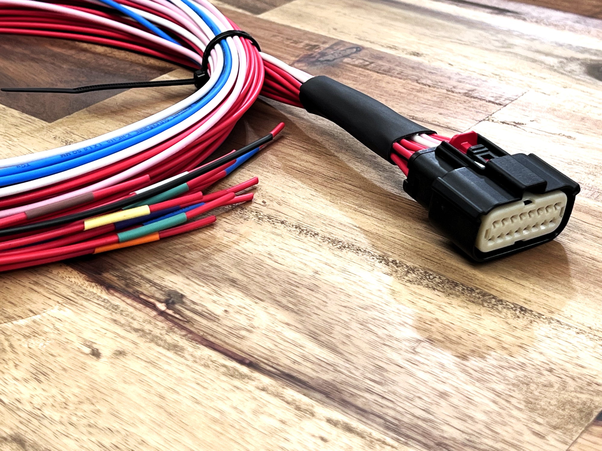 Colorful wiring harness with connectors on a wooden surface