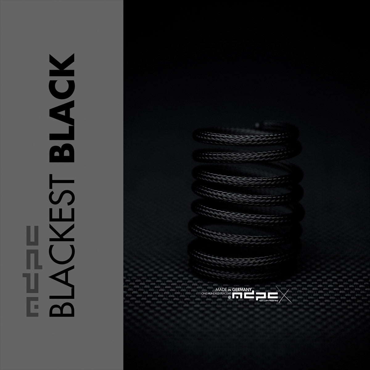 Stack of black springs with 'Blackest Black' text and MRC branding on a dark background