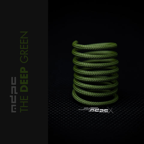 The Deep Green Braided Cable Sleeve displayed in a spiral on a dark background, showcasing its premium quality and unique color.