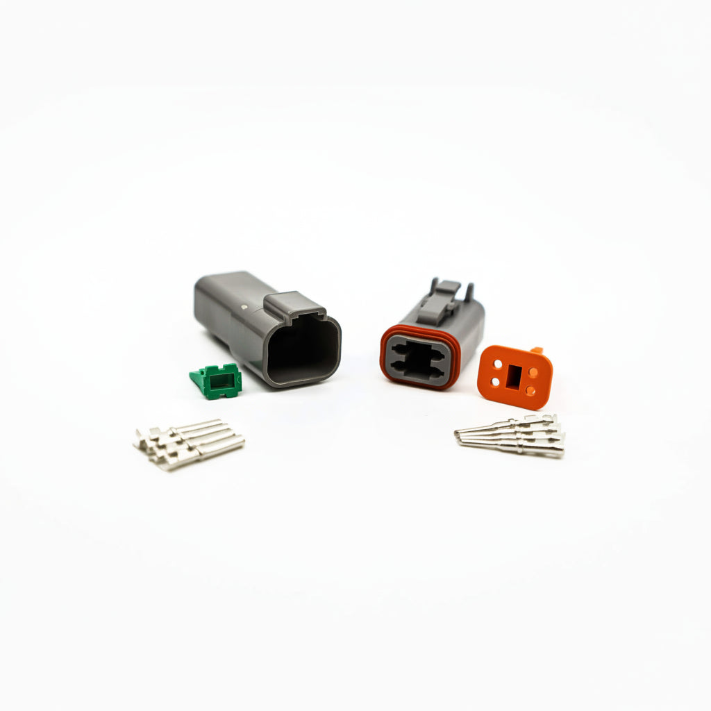 A photo showing a non-genuine Deutsch 4-pin DT connector kit, including a black connector body and several wire connectors.